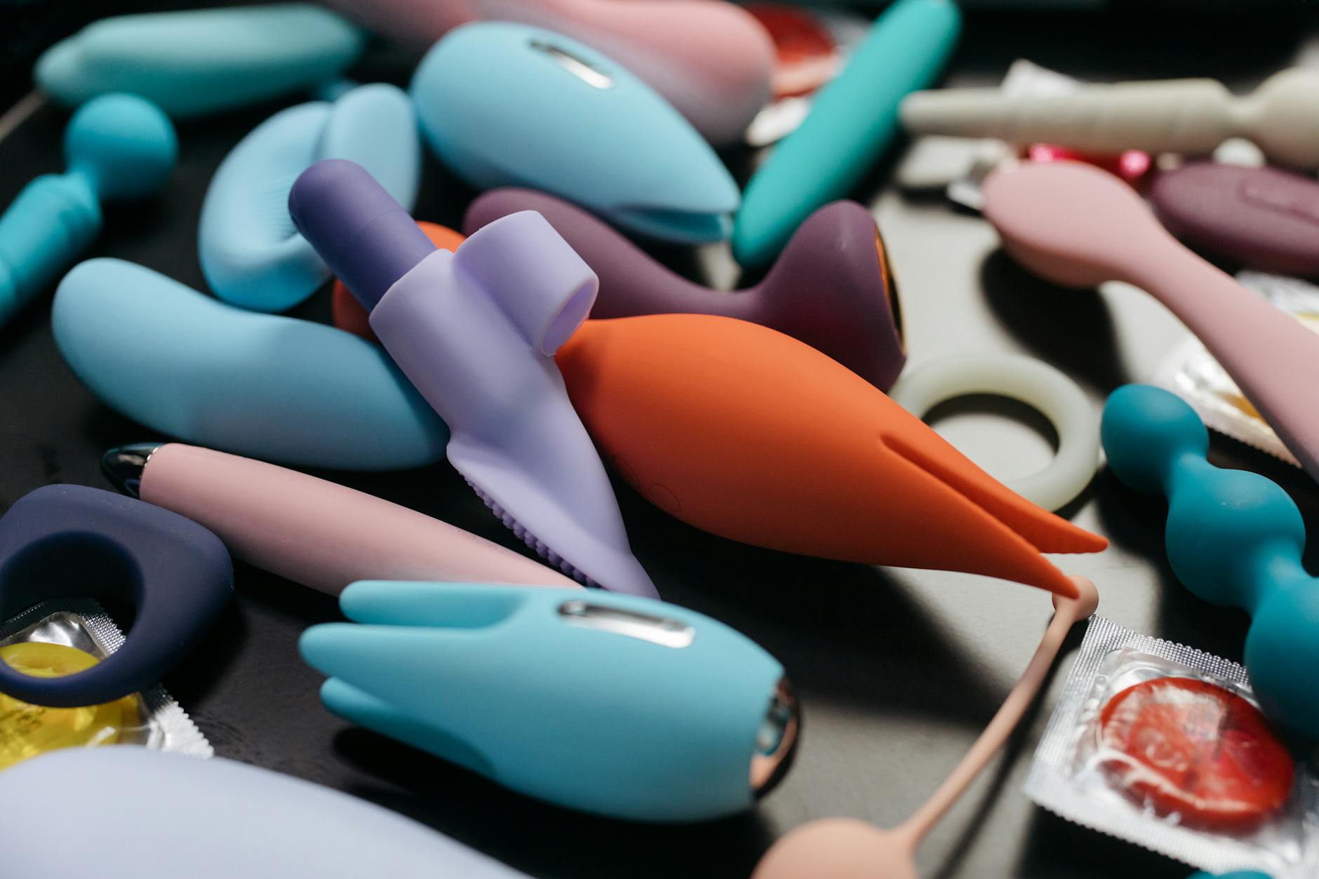 Close-up hands holding a blue lemon clitoral vibrator against a purple background