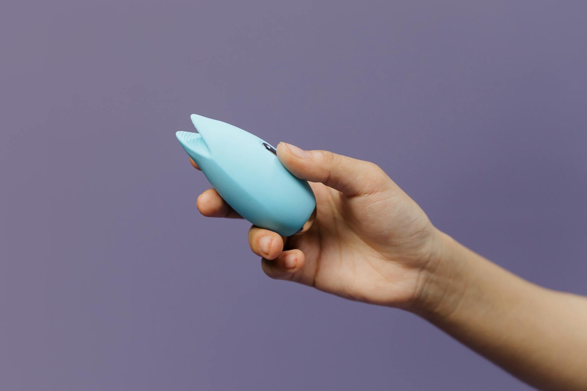 A silicone vibrator held in hand, representing tools for pleasure and connection