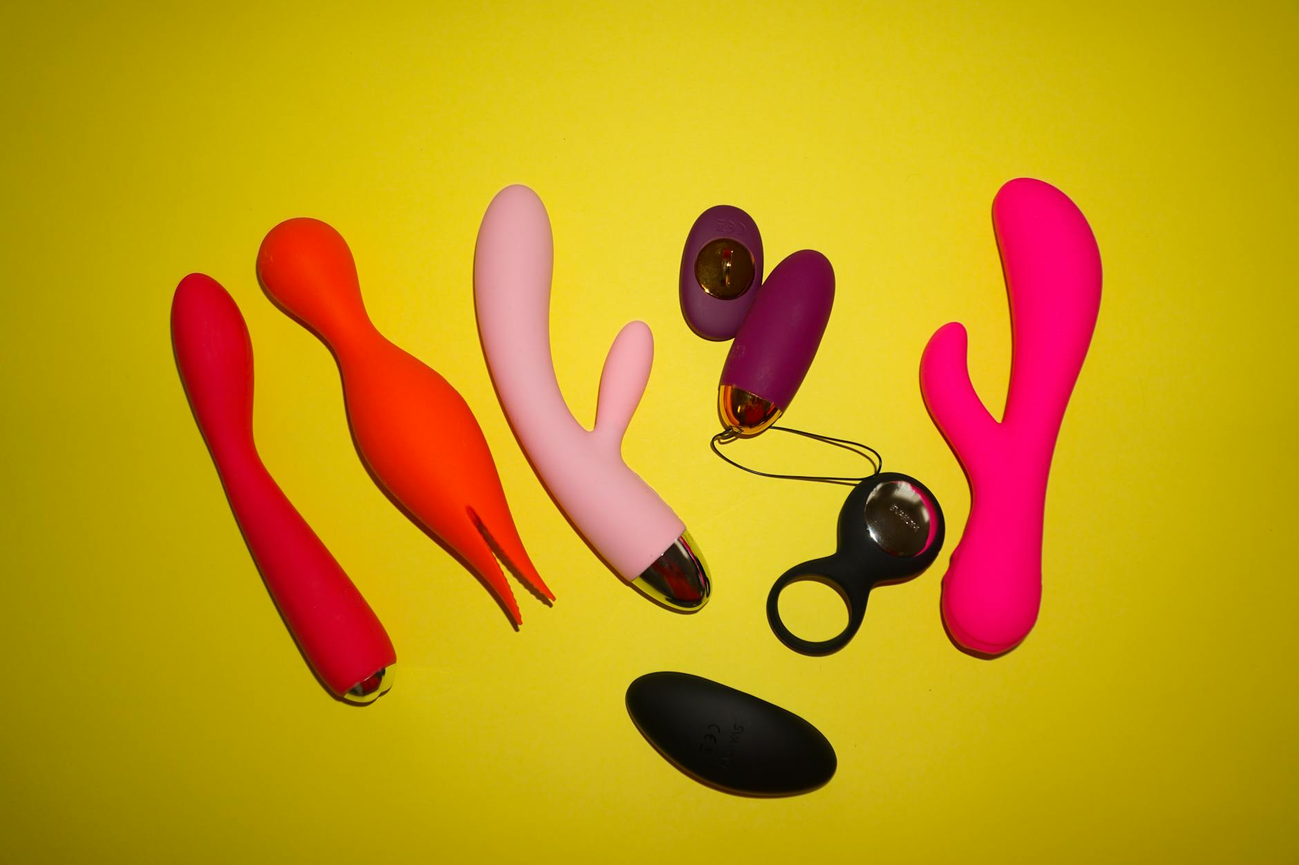 Hands holding a sleek clitoral vibrator against a soft purple background, representing self-connection and intimate wellness